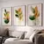 Três quadros decorativos com ilustrações de flores em tons verdes e laranja, emoldurados, pendurados na parede acima de um sofá claro.