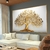 Quadro decorativo em estilo moderno com uma árvore da vida dourada, destacando suas folhas e galhos, pendurado em uma parede clara acima de um sofá.