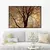 Quadro decorativo com galhos secos em um fundo laranja, exibido em uma sala moderna.