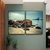 Dois quadros decorativos com imagem de pedras na praia e mar ao fundo, em um ambiente moderno.