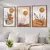 Três quadros decorativos em estilo boho abstrato com flores em tons neutros e laranjas, pendurados em uma parede ao lado de um sofá com almofadas.