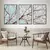 Trio de quadros decorativos com cerejeiras em fundo azul, exibindo flores brancas em um ambiente moderno.