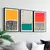 Trio de quadros decorativos abstratos nas cores amarelo, azul e vermelho, com formas geométricas e padrões variados, emoldurados em preto.