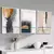 Trio de quadros decorativos abstratos em tons terrosos e azul, com molduras brancas, expostos em uma parede cinza.