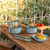 Batería de cocina antiadherente de 6 piezas Línea Botanika de Brinox sobre mesa de madera