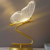 Luminária de mesa em formato de borboleta com design moderno e iluminação suave.