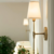 Arandela de parede estilo nórdico moderno com cúpula branca e estrutura dourada, iluminando um ambiente sofisticado.