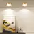 Plafon refletor LED de teto com três cores de luz, instalado em um ambiente moderno com quadro decorativo e objetos de enfeite.