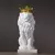 Escultura de um leão branco com uma coroa dourada, simbolizando majestade e elegância.