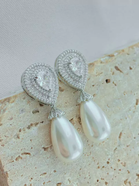 BRINCO GOTA CRAVEJADO BAGUETE PEROLA RODIO BRANCO