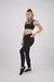 Calza deportiva lisa negra para mujer con bolsillo lateral.