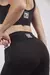 Calza deportiva lisa negra para mujer con bolsillo lateral.