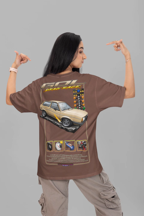 Mulher de costas usando camiseta oversized marrom com estampa de carro Gol drag race e elementos gráficos relacionados a corrida