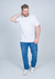 Camiseta plus size básica lisa em algodão, modelo masculino, usando jeans e tênis.