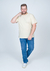 Camiseta básica lisa em algodão bege, modelo plus size, sendo vestida por um homem sorridente, posando em pé com jeans e tênis.