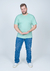 Homem usando uma camiseta plus size básica lisa na cor verde clara, posando de forma casual.