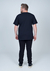 Homem usando camiseta plus size preta de 100% algodão, vista de costas.