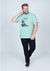 Camiseta plus size verde claro com estampa, modelo masculino posando em pé.
