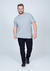 Camiseta Plus Size Básica Lisa de cor cinza, feita 100% de algodão, modelo masculino usando calça preta.