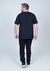 Camiseta Plus Size 100% Algodão Limits Preta vista traseira, modelo masculino usando calças pretas e sapatos escuros.