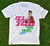 Camisa branca com estampa vibrante, destacando a frase "IT'S ONLY A GAME" e referências a guerra, sangue, suor e lágrimas no contexto do futebol.