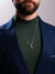 Homem usando corrente de prata 925 veneziana da Morelli Joias com pingente de jade verde em formato quadrado, vestido com camiseta verde e blazer azul