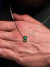 Corrente de prata 925 com pingente de jade verde sendo exibida em uma mão.