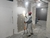 Trabalhador utilizando um disco de lixa de 225mm em parede em reforma, com equipamentos de proteção e iluminação adequada.