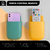 Organizador porta control remoto en colores verde y amarillo, con un control remoto y un teléfono móvil en sus respectivos compartimentos.