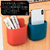 Organizador porta control remoto en colores rojo y azul, con espacio para bolígrafos y un teléfono móvil.