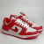 Tênis feminino Nike Dunk Low nas cores vermelho e branco, feito de couro, exibido em uma posição lateral.