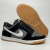 Tênis Nike Dunk Low feminino na cor cinza e preto, com detalhes em material sintético e camurça, posicionado de lado com a sola visível.