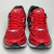 Tênis Mizuno Wave Creation 20 nas cores vermelho e grafite laranja, vistos de cima.