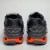 Tênis Mizuno Wave Creation 20 nas cores vermelho, grafite e laranja, vistos de trás.