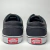 Vista traseira de dois pares de tênis Vans Authentic nas cores preto e branco.