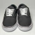 Tênis Vans Authentic na cor preto com detalhes em branco, mostrando a parte frontal e os cadarços brancos.