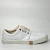 Sapatênis branco da marca Reserva, com detalhes em dourado e sola branca, ideal para um look casual masculino.
