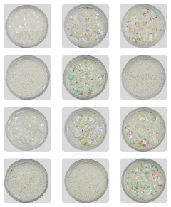 Doze potes grandes de glitter flocado em tons variados de branco e transparente com reflexos coloridos, organizados em três linhas de quatro potes cada.