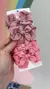 Conjunto de laços em tons de rosa, com três laços diferentes, em um fundo colorido.