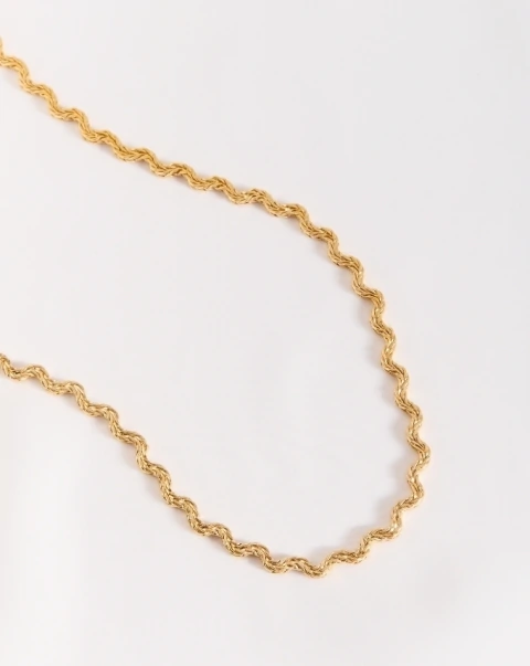 Choker dourado com design ondulado e acabamento polido, peça da coleção Continuidade.