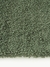 Alfombra rectangular de color verde, con textura suave y pelo corto.