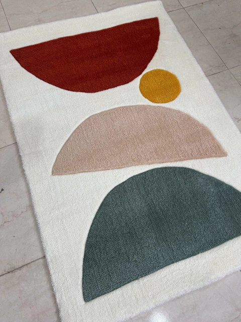 Alfombra rectangular Doux con diseño geométrico en colores terracota, mostaza, beige y verde sobre fondo blanco