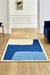 Alfombra Zenith en tonos azules y beige, colocada en un suelo de madera clara, con decoración minimalista en el fondo.