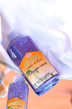 Botella de sales de baño aromáticas aromARTE de color morado, violeta con etiqueta de "Cereza-uva".