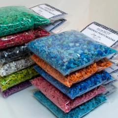 Piedras perfumadas con aceite esencial aromARTE de diferentes colores en bolsas transparentes.