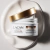 Máscara Maxi Hidratante Argan Oil da Lacan em um pote com tampa dourada, sobre uma superfície creme.