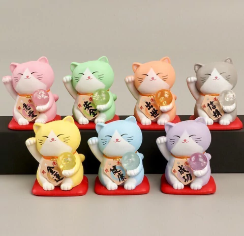 Maneki Neko pequeños de resina en colores pastel, con patita levantada en pose elegante y esferita brillante.
