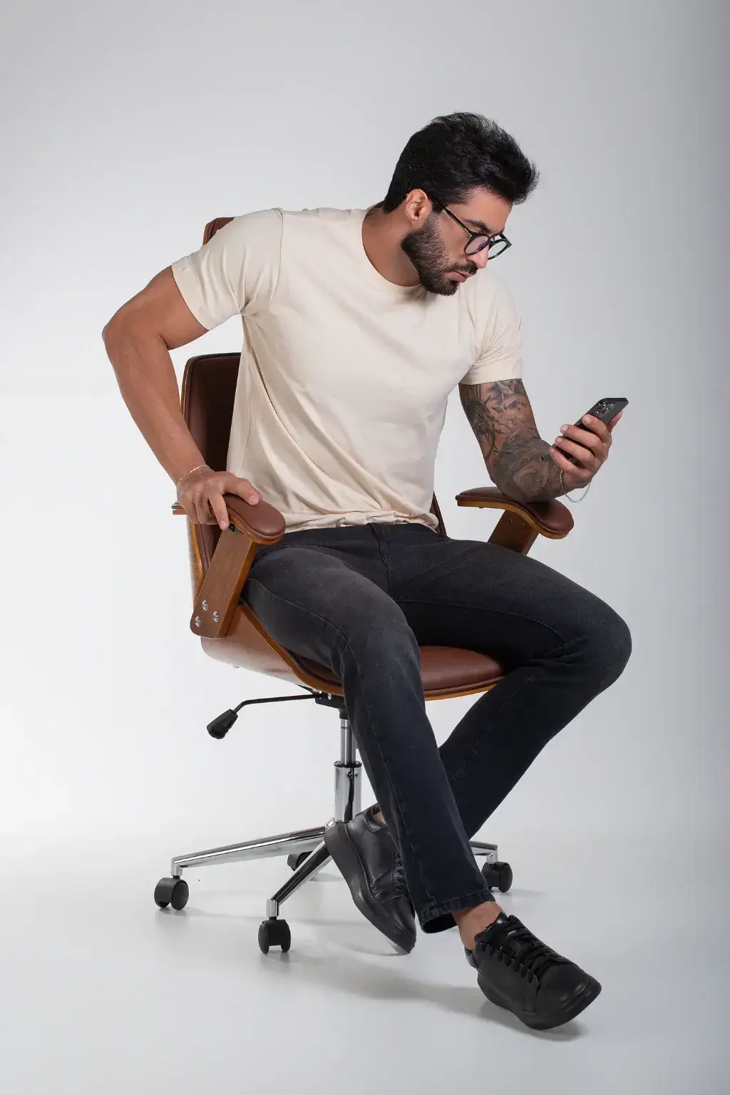 Modelo usando a camiseta Supreme Palha sentado em uma cadeira, em estúdio, mostrando o caimento no corpo.