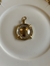 Pingente em dourado escrito fé, com 5cm de comprimento.