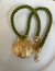 Corda verde com concha em dourado. - comprar online